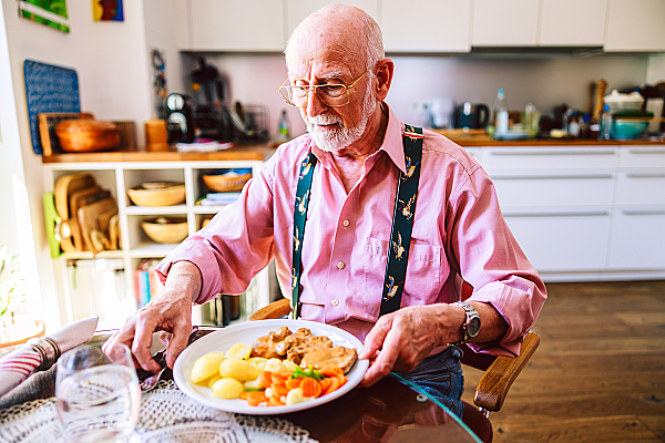 Älterer Herr  vor einem gelieferten Mittagessen