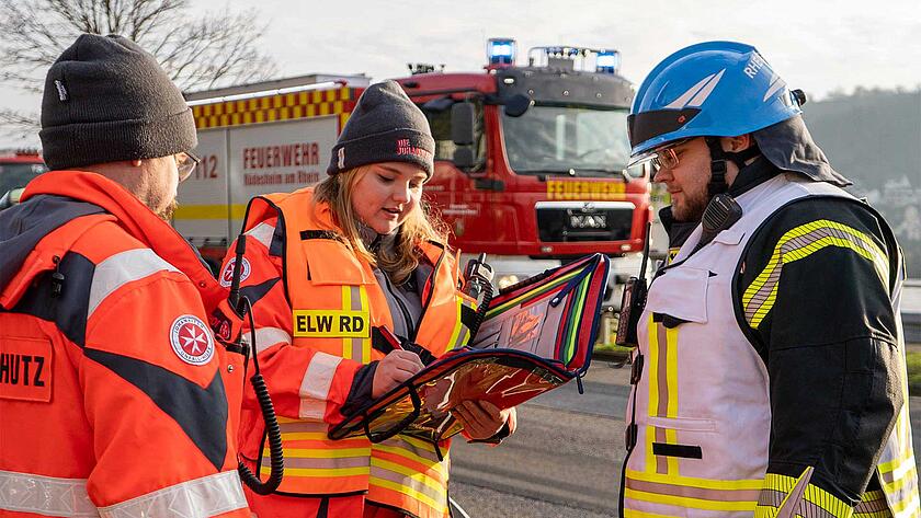 Einsatzkräfte des Einsatzleitwagen Rettungsdienst im Rheingau-Taunus-Kreis der Johanniter besprechen sich in einem Einsatz.