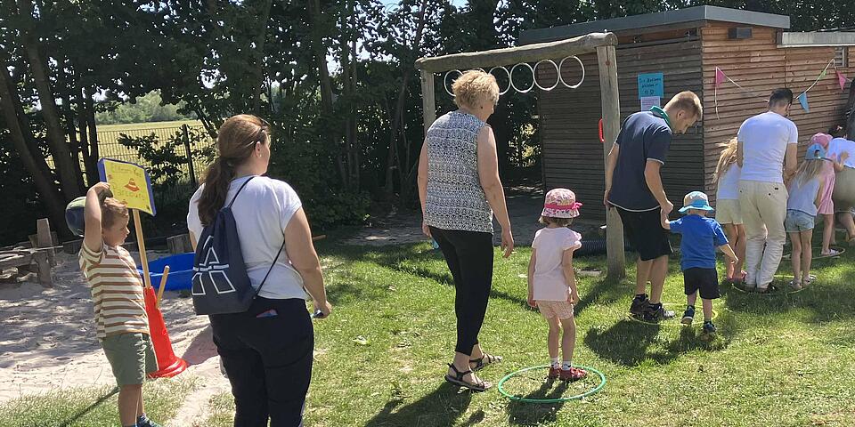 Eltern und Kinder stehen in einer Schlange