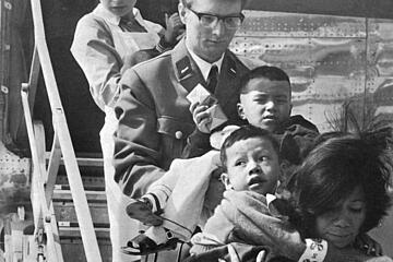 Helferinnen und Helfer nehmen im Jahr 1970 auf dem Hamburger Flughafen verletzte Kinder aus Vietnam in Empfang.