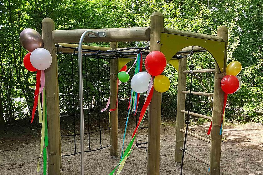 Ein Klettergerüst ist mit Ballons und Luftschlangen dekoriert.