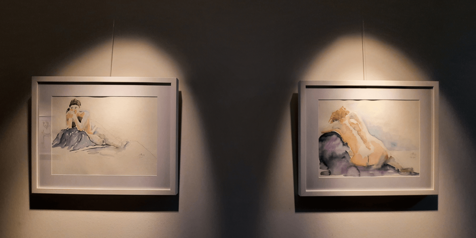 zwei Aquarellbilder, die von scheinwerfern beleuchtet sind