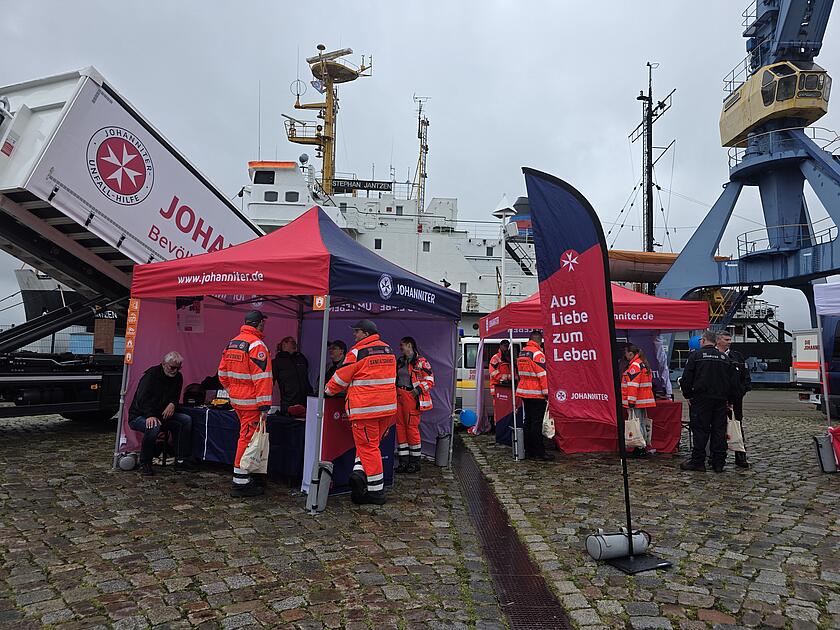 zwei Johanniter-Stände mit Ehrenamtlichen Helfern und Besuchern des Bevölkerungsschutztages