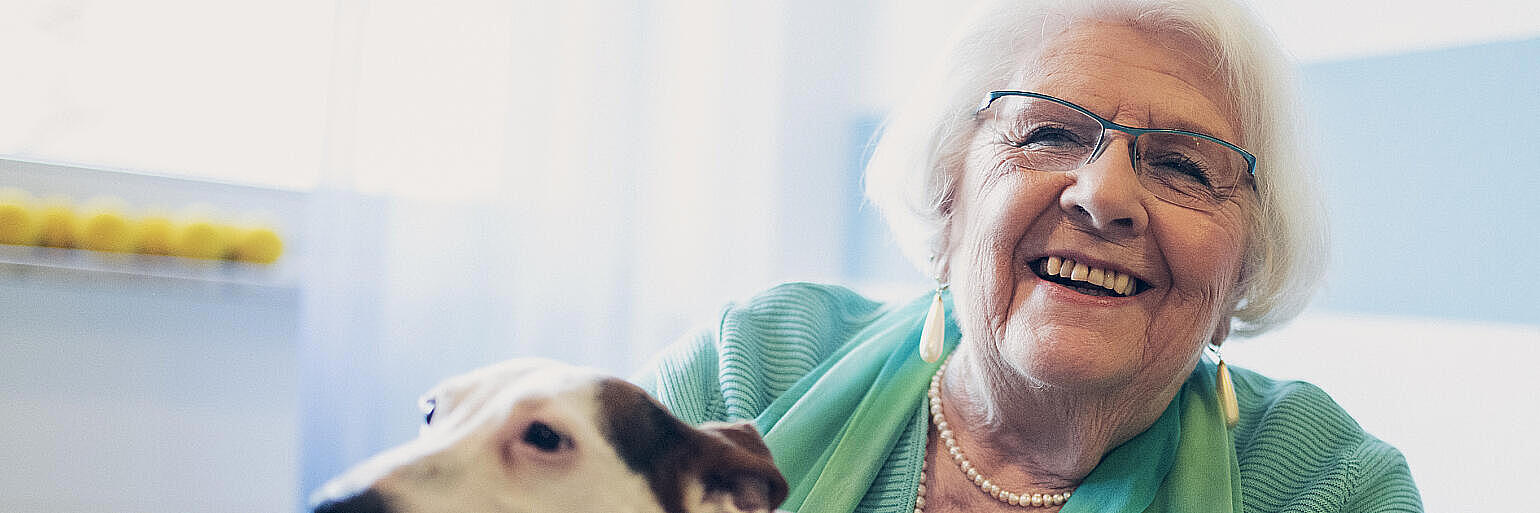 Eine Frau kuschelt mit einem Hund