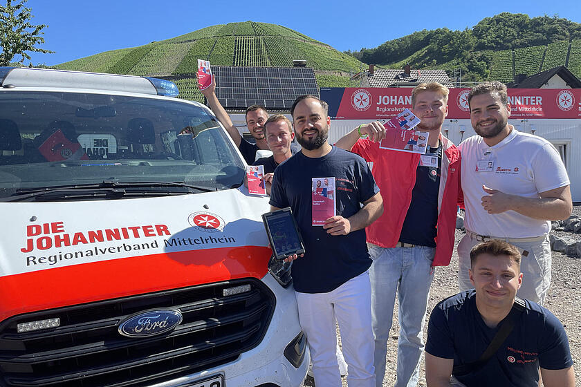 Gruppenfoto von Mitarbeitern: Sie halten ein Fördermitgliedschaftsflyer in die Kamera