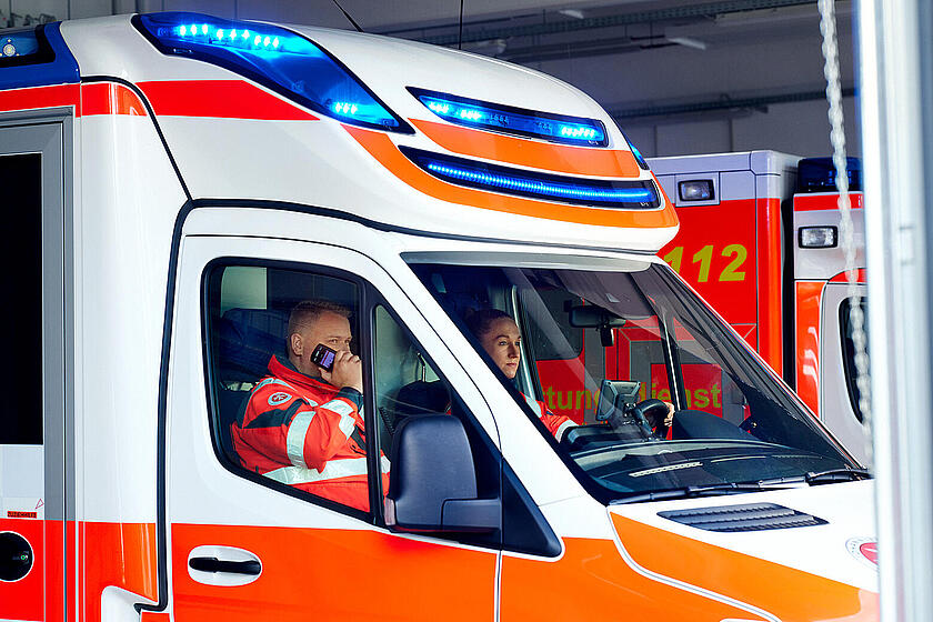 Zwei Johanniter sitzen in einem Rettungswagen.