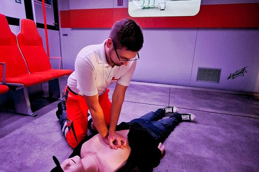Ein Mitarbeiter übt Herz-Lungen-Wiederbelebung an einer Puppe