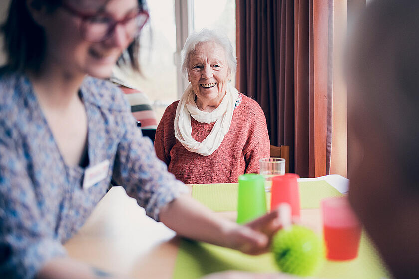 Eine Seniorin und eine Mitarbeiterin bei einem Spiel