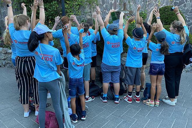 Die Kinder der Ferienbetreuung strecken die Hände in die Luft