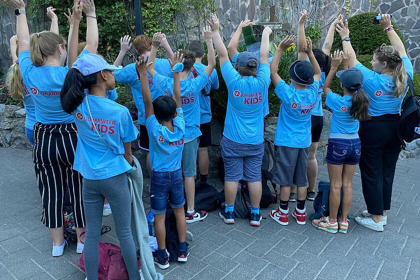 Die Kinder der Ferienbetreuung strecken die Hände in die Luft