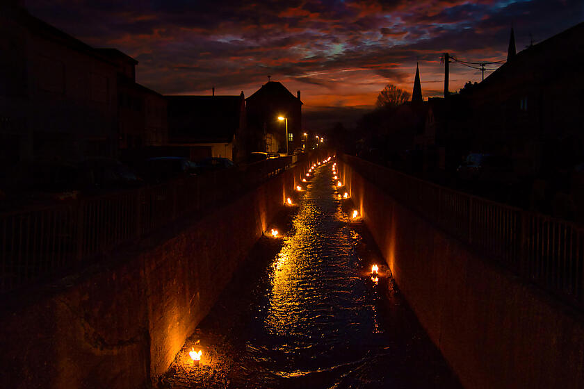 Das Foto zeigt den mit Fackeln beleuchteten Orbach bei Nacht.