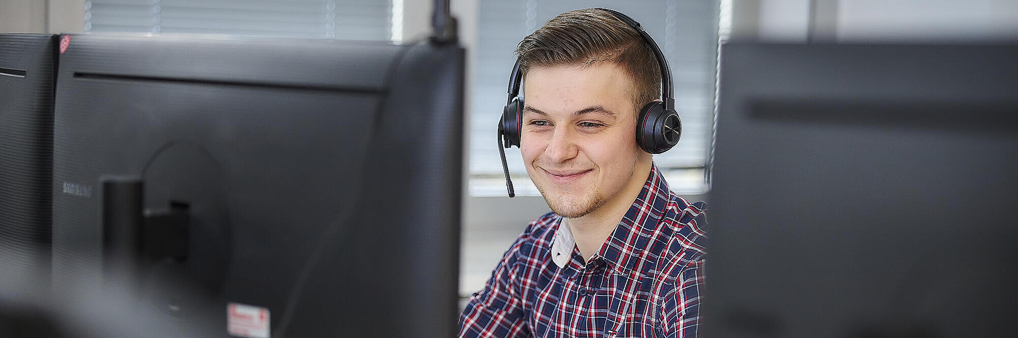 Mitarbeitende Person vor PC-Bildschirm
