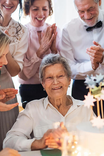 Älteres Paar feiert goldene Hochzeit und ist umgeben von Angehörigen