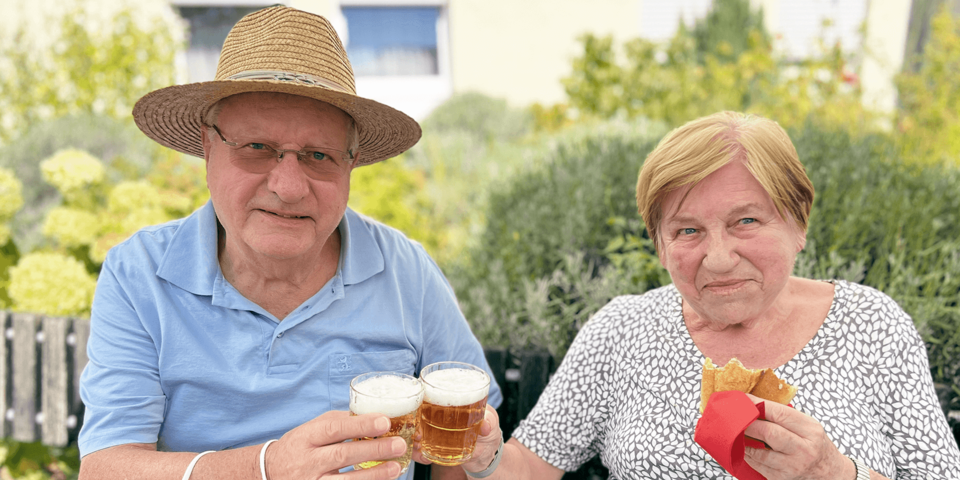 Ein Mann und eine Frau stoßen mit Bier an.