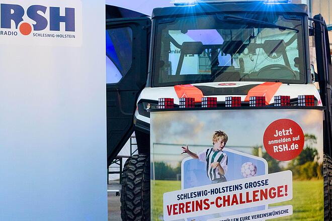 Das Gelände-Nutzfahrzeug mit dem Challenge-Plakat 