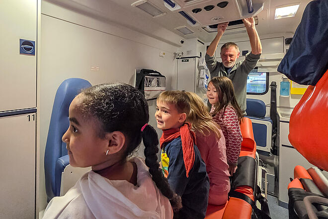 Traumland besucht Ortsgruppe Bergedorf Die Kinder der Johanniter-Kita Traumland inspizierten einen Krankentransportwagen und testeten bei der Gelegenheit die Funktionsweise der Patiententrage.