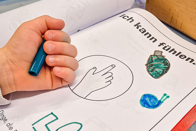 Auf einem Tisch liegt ein Heft mit einem Arbeitsblatt zum Thema "Ich kann fühlen".
