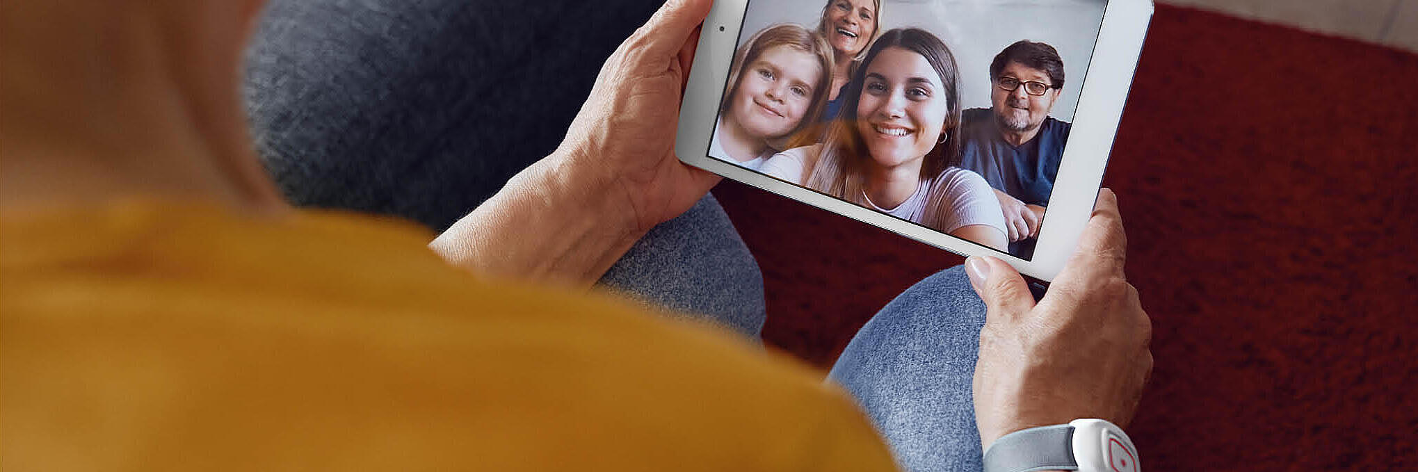 Eine Person hält ein Bild von der Familie in der Hand