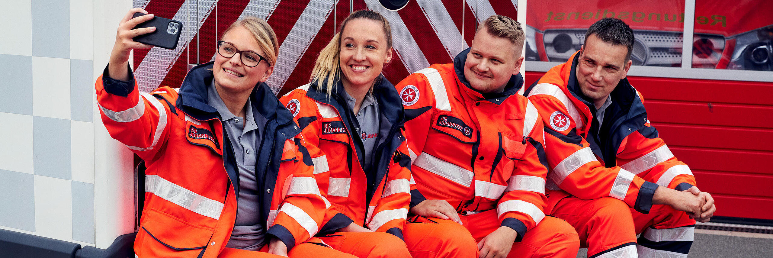Eine Gruppe von Rettungskräften posiert vor dem Einsatzwagen.