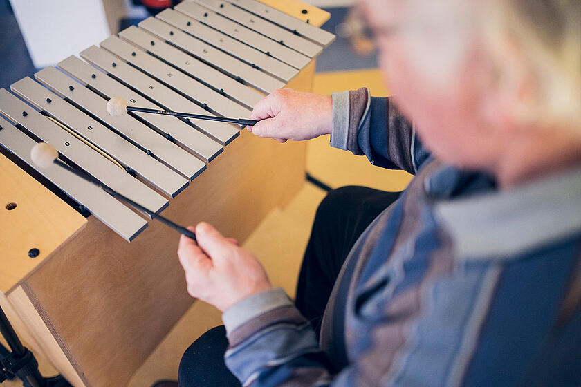 Eine Bewohnerin spielt ein Holzinstrument