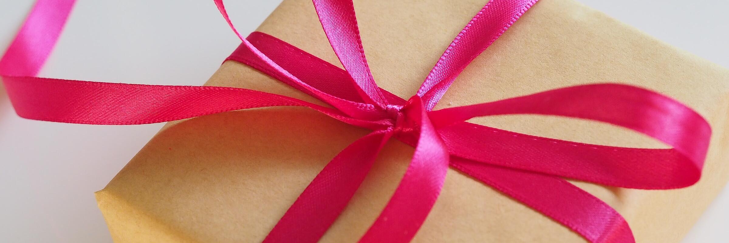 braun verpacktes Geschenk mit roter Schleife