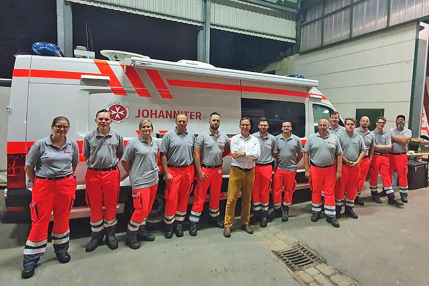 Johanniter und Dr. Kroll vor einem Einsatzwagen