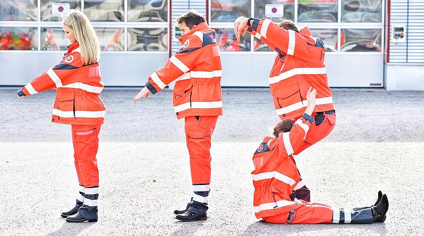 Vier Johanniter Mitarbeiter bilden mit ihren Körper 112