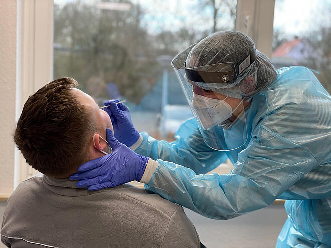 Eine Mitarbeiterin der Johanniter-Unfall-Hilfe macht einen Abstrich für einen Corona-Test bei einem Patienten.