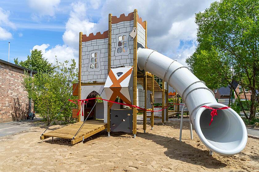 Das neue Spielgerät der Kita Zwergenwache ist eine Ritterburg mit Kletterelementen, einer Tunnelrutsche und einer Hängebrücke.