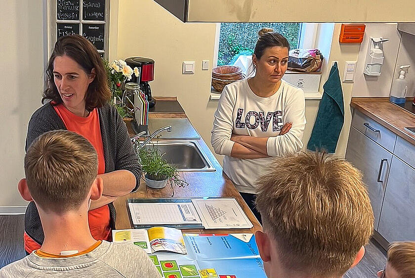 Ernährungsberaterin Susanne Kruse (l.) erklärte den Kindern und Jugendlichen, die im Wohnhaus der stationären Jugendhilfe leben, was gesunde Ernährung bedeutet und wie sie selbst herausfinden können, was in Lebensmitteln enthalten ist.
