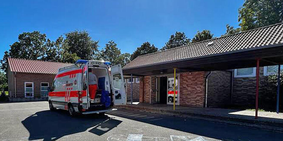 Ein Rettungswagen vor einer Schule