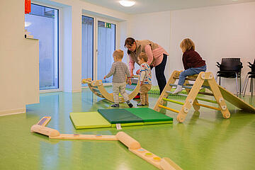 Kinder sind mit Erzieherinnen im Turnraum und spielen