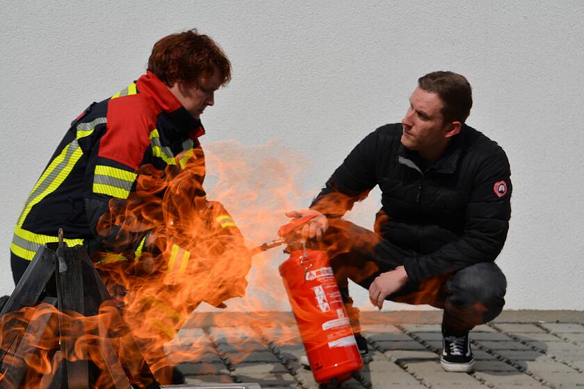 Bild mit Personen des Brandschutzes die mit Feuer interagieren