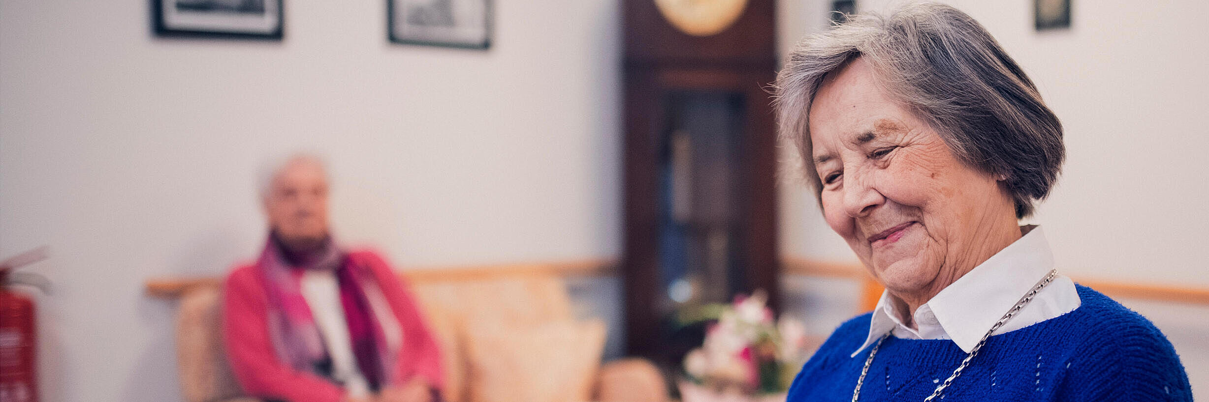 Eine Bewohnerin in blauem Pullover liest im Johanniter-Stift