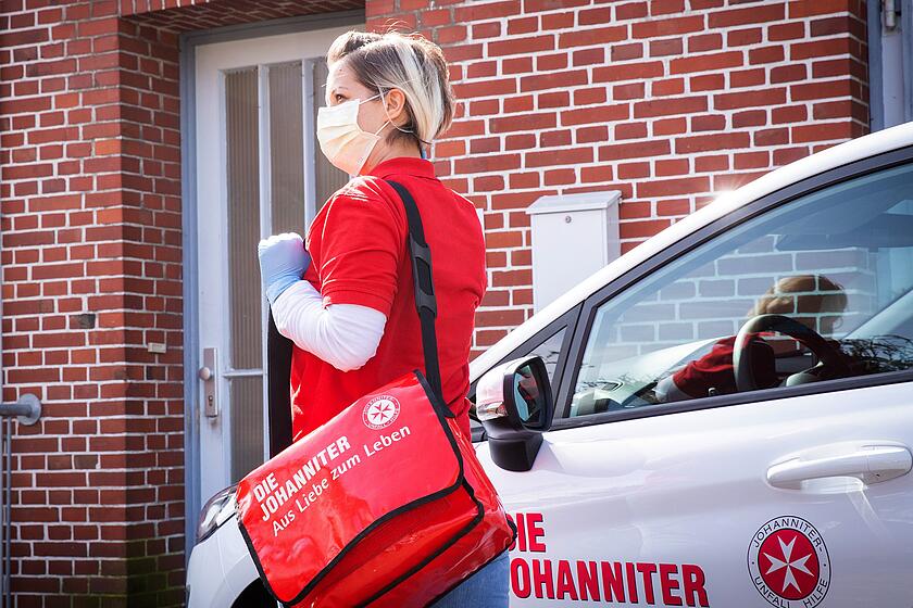 Johanniter-Pflegekraft mit Mundschutz