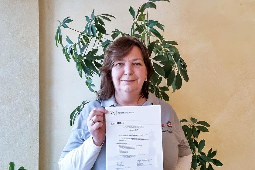 Stolz präsentiert Kerstin Baß ihre Urkunde: Sie hat ihre Weiterbildung zur Praxisanleiterin erfolgreich abgeschlossen und steht künftigen Auszubildenden im Ambulanten Pflegedienst Stormarn zur Seite.