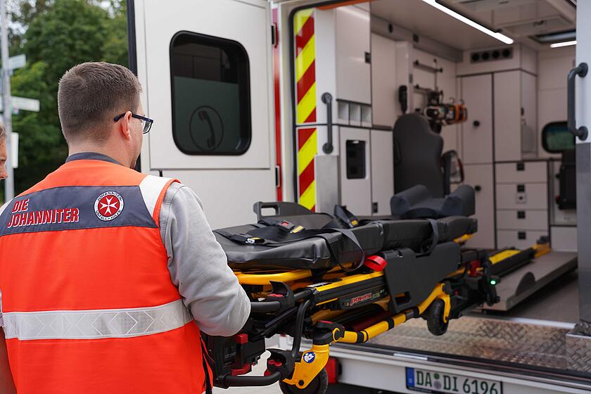 Notfallsanitäter schiebt die Trage in den RTW