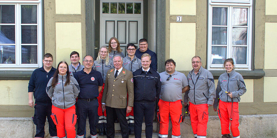 Eine Menschenmenge in Johanniter-Einsatzkleidung. In der Mitte steht ein Mann in Johanniter-Gala-Uniform