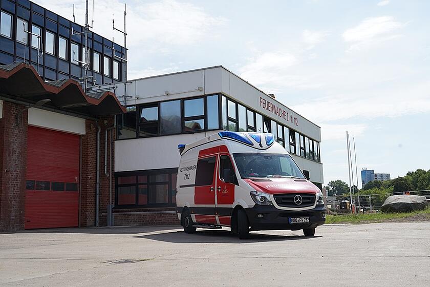 Man sieht einen Krankenwagen stehend vor der Wache, die ziemlich groß ist