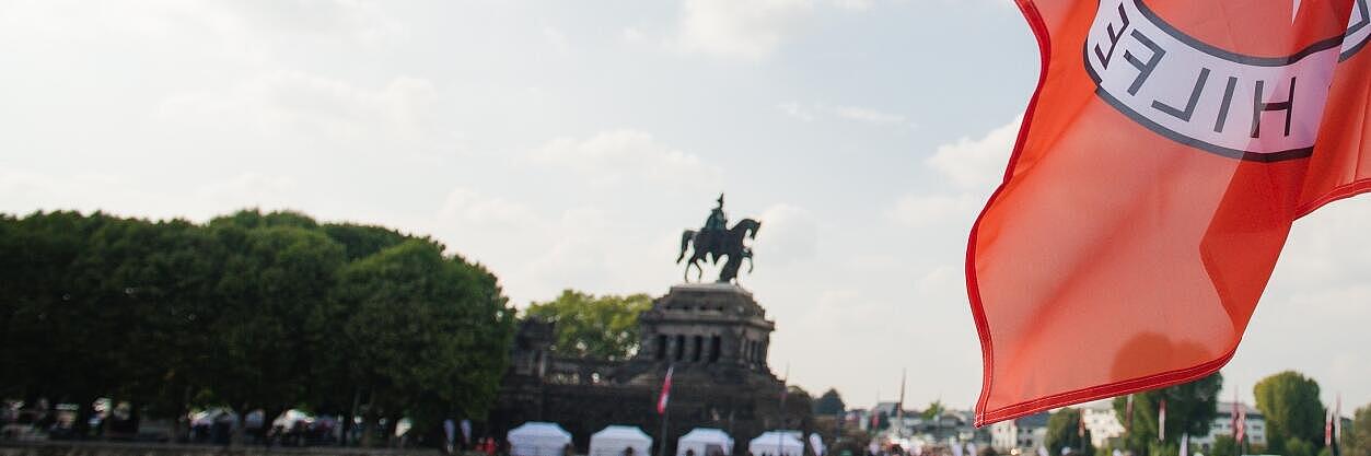 Eine JUH-Flagge seht auf der rechten Rheinseite. Im Hintergrund ist das Deutsche Eck zu sehen. 