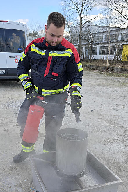 Ein Ausbilder der seniorenzeit.livemonstriert den Umgang mit einem Feuerlöscher