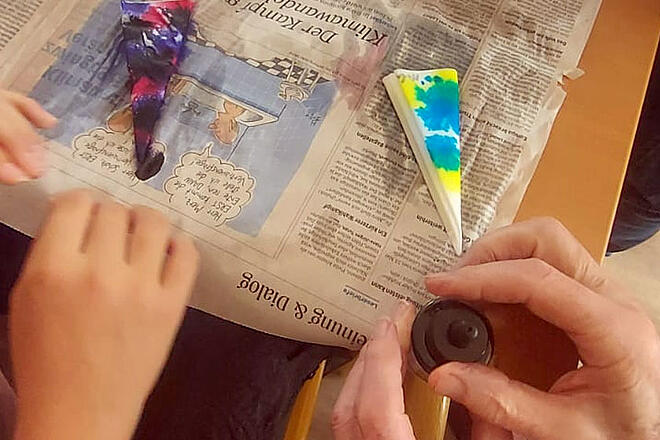 Auf einer Zeitung liegen bunte selbst gebastelte Sachen.
