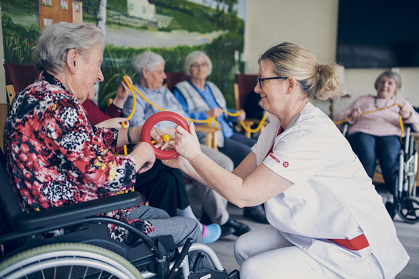 Eine Gruppe von Senioren bei sportlicher Aktivität mit Ringen 