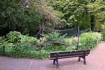 Gartenbank stehend zum Teich im Johanniterhaus Bonn.
