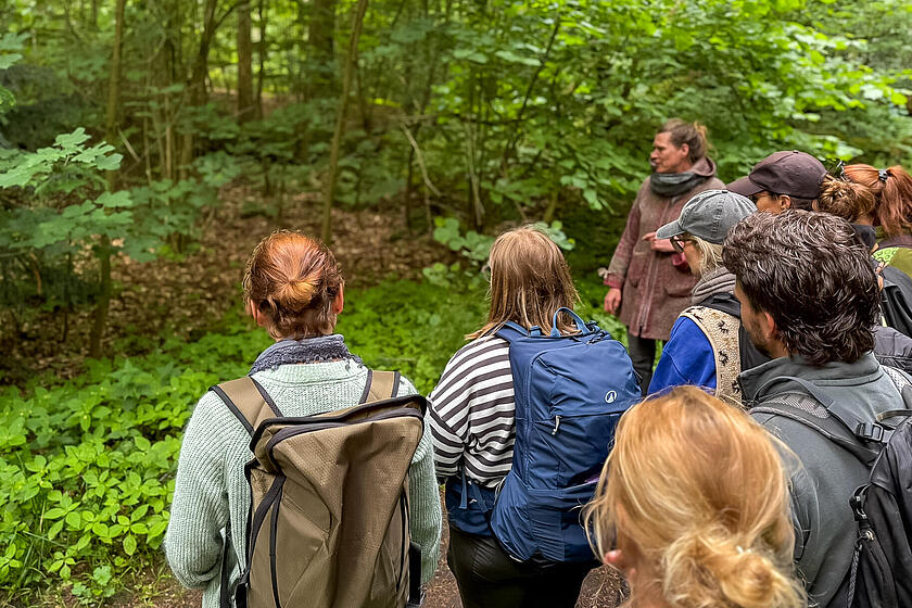 Mehrere Personen stehen im Wald.