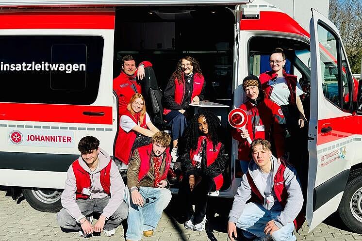 Mehrere junge Menschen des Spendenteams sitzen im Einsatzleitwagen der Johanniter.