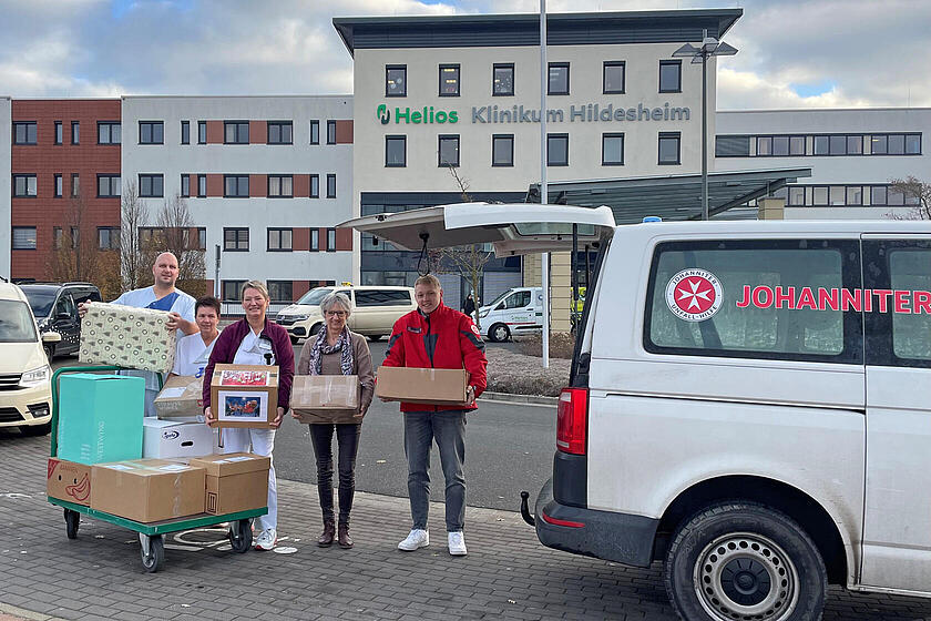 4 Personen mit Paketen vor dem Helios Klinikum
