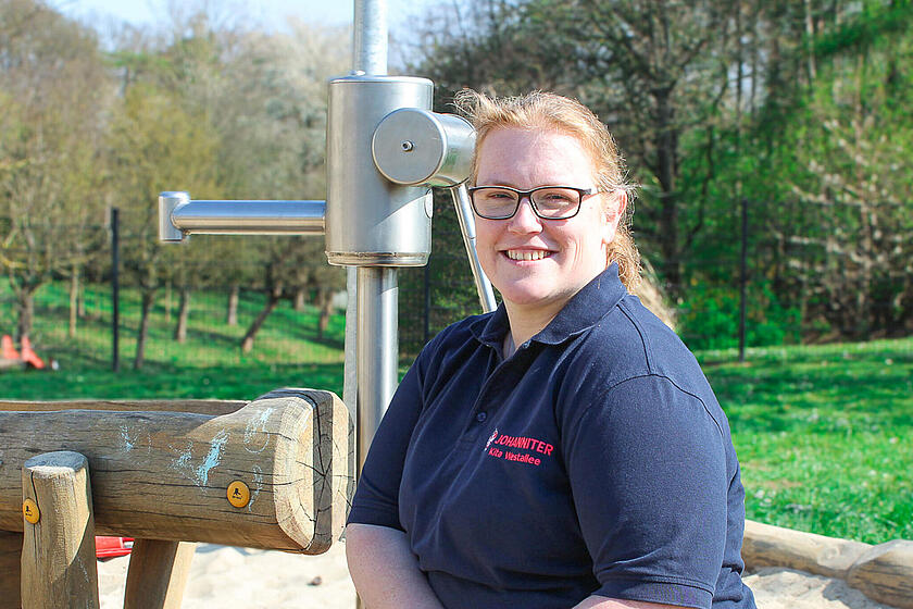 Eine Frau mit Johanniter-Polo-Shirt im Grünen