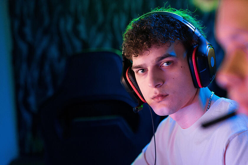 Ein junger Mann mit Headset schaut in die Kamera.
