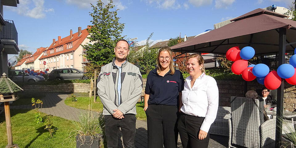 Ein Mann und zwei Frauen in einem Garten.